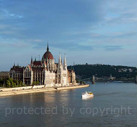 Budapest parliament on the Danube bankside and tourist boat photo